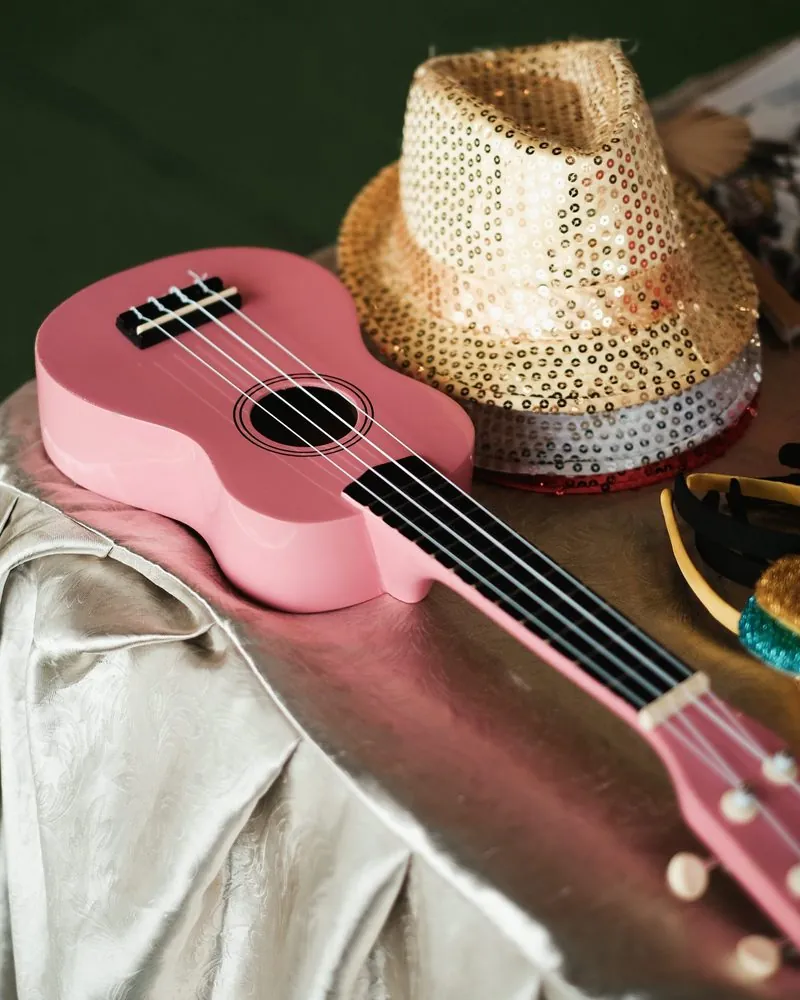 Pink ukulele and sequin hat props for the photobooth